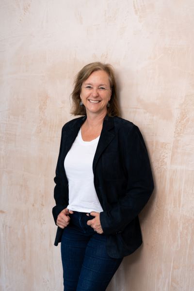 A picture of Suzanne Smith standing in front of a plastered wall