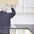 Image shows a person installing kitchen units